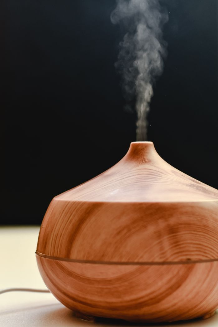 services-02 A wooden diffuser releasing calming steam against a black background, ideal for relaxation and aromatherapy stock images.